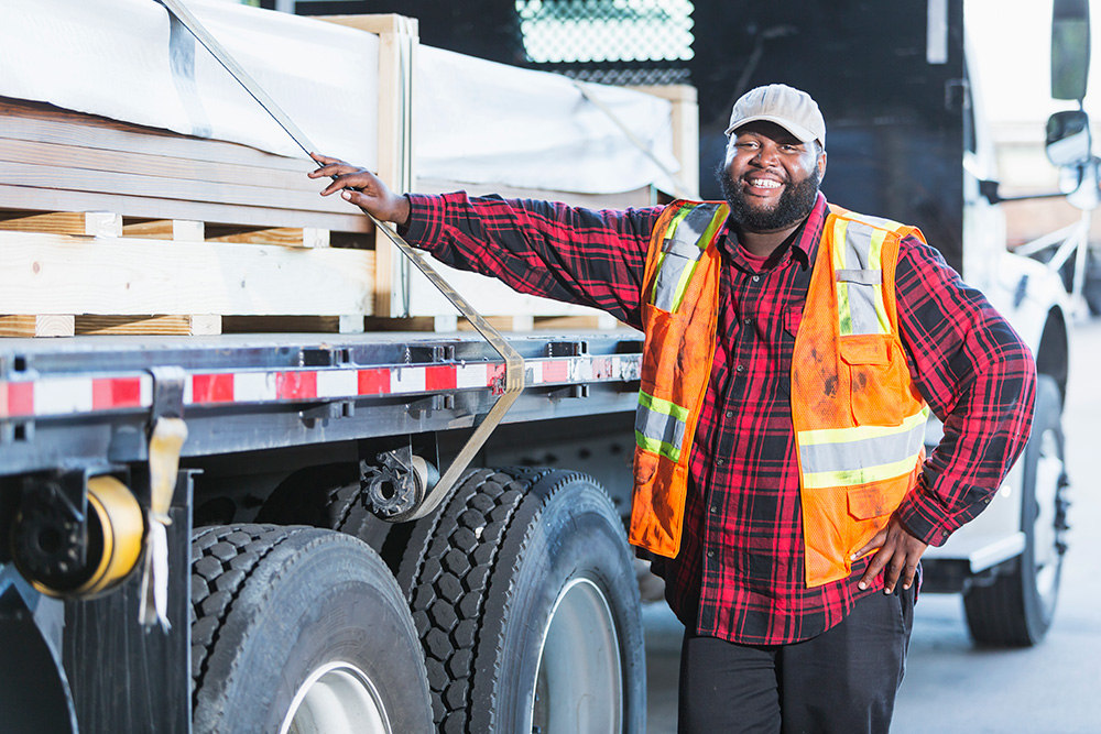 portrait of a driver in front of his semi truck