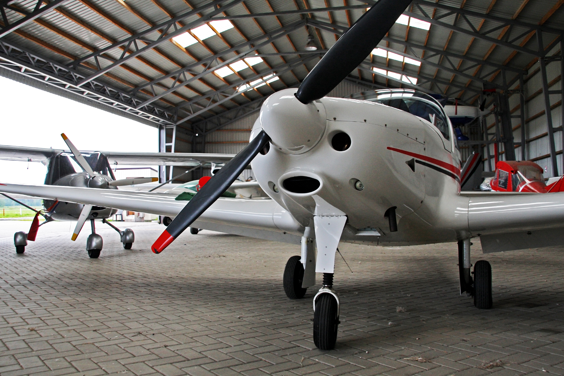 Small white plain with red trim in a hangar